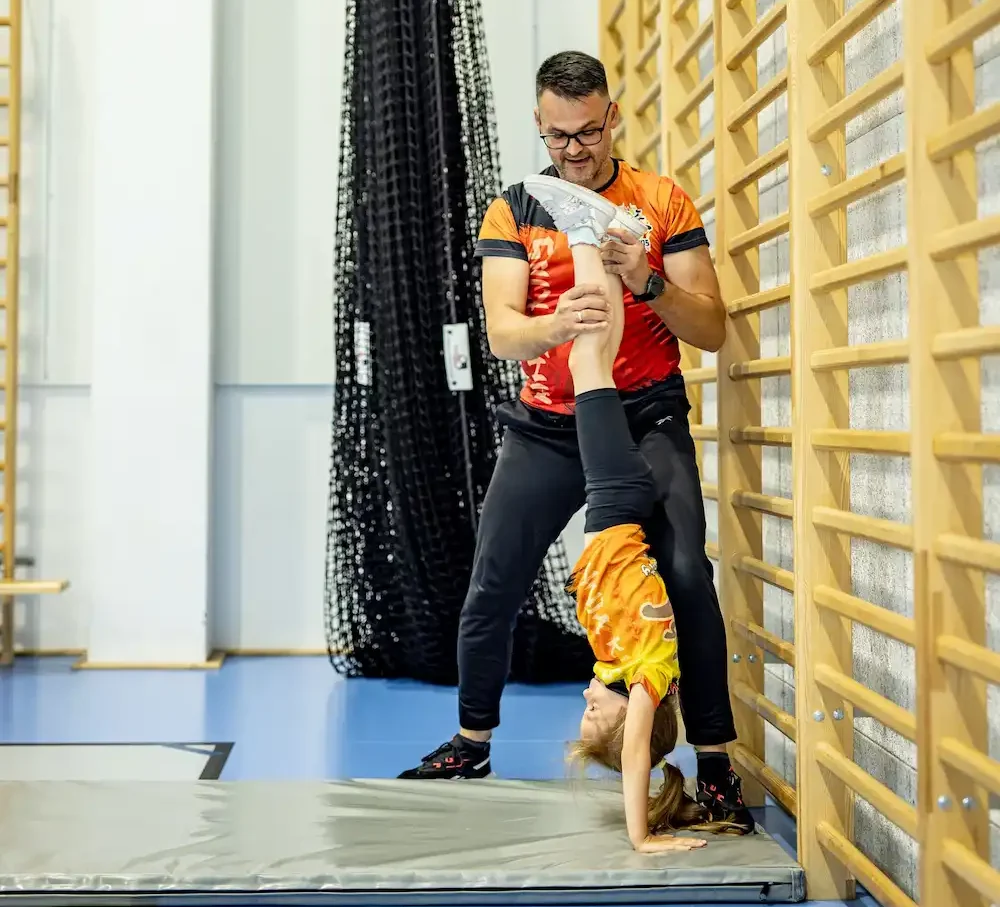 Strona główna 3 Wychowawca Ninja Kids Academy uczący dziecko stawać na rękach