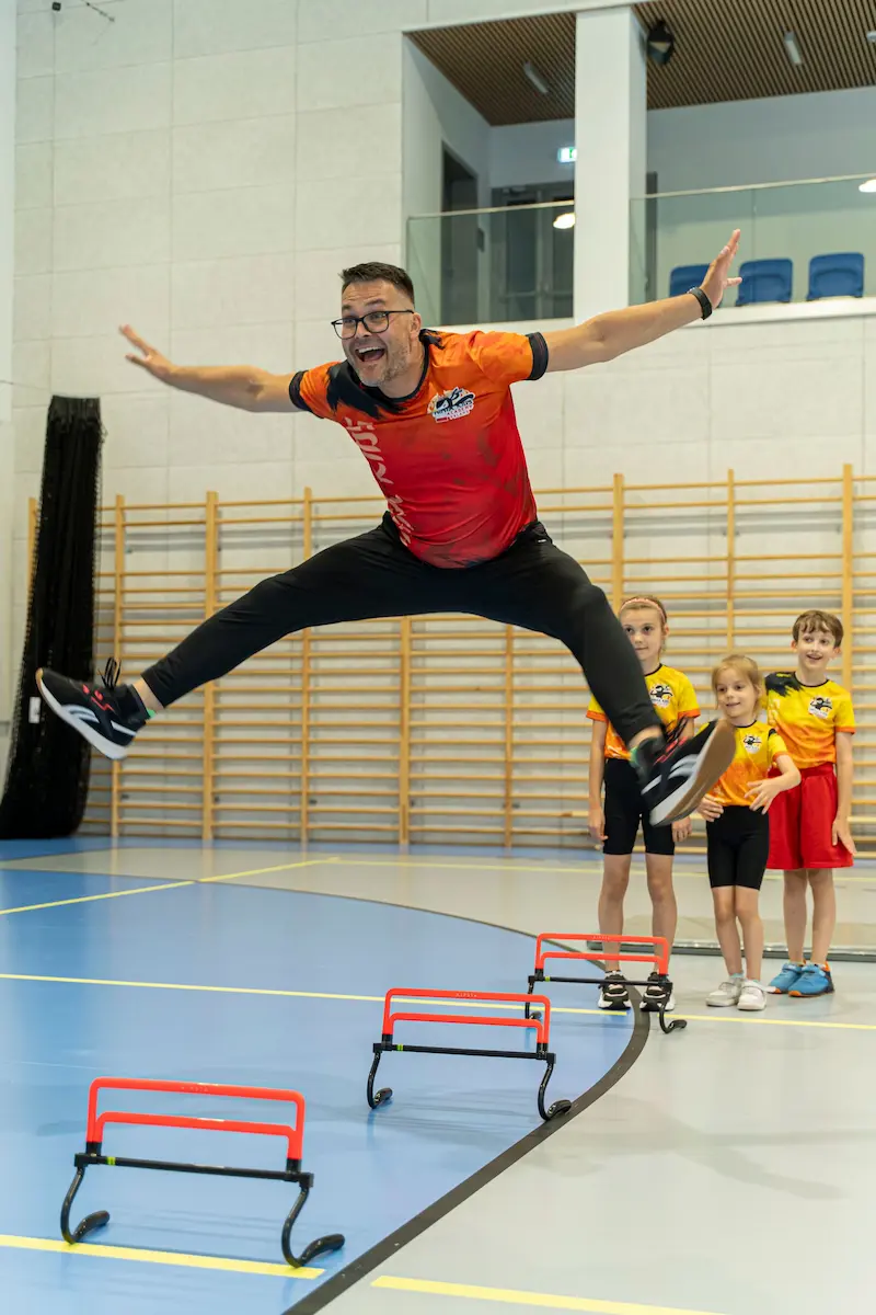 Rekrutacja trenerów 2 Trener Ninja Kids robi wielki wyskok nad przeszkodami.